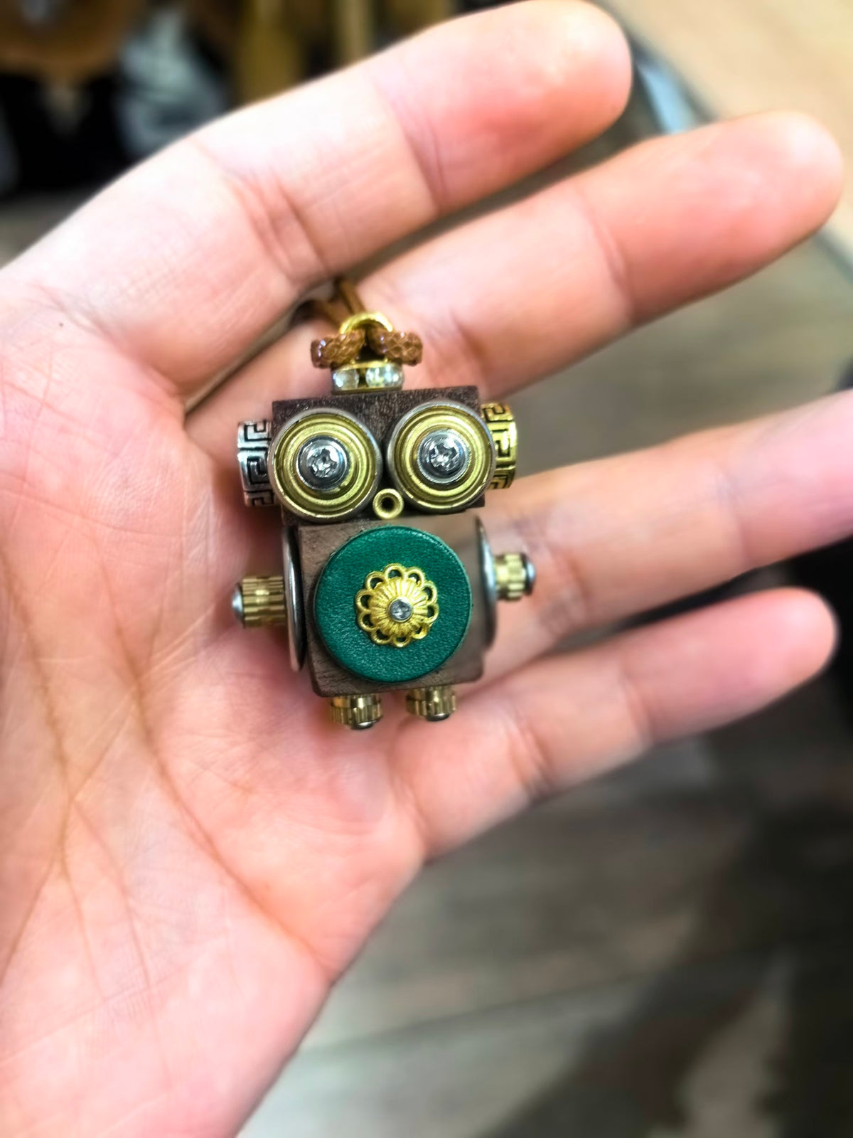 Golden-Eyed Steampunk Robot Pendant with Green Floral Detail